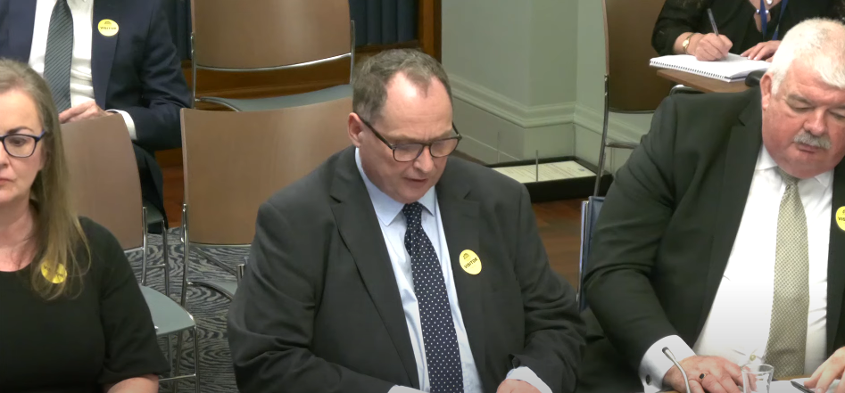 two men and a woman presenting to politicians